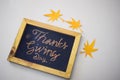 The word Thanksgiving written by hand on a blackboard in white/grey background Royalty Free Stock Photo