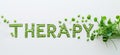 Word THERAPY created with green pills and fresh leaves on white background. Concept of alternative medicine, green Royalty Free Stock Photo