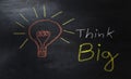 Word think big and light bulb drawn with colorful chalk on a blackboard, business concept Royalty Free Stock Photo