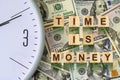 Word, Time Is Money composed of letters on wooden building blocks against the background of dollar bills. Concept business, financ Royalty Free Stock Photo
