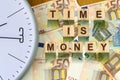 Word, Time Is Money composed of letters on wooden building blocks against the background of Euro banknotes. Concept business, fina Royalty Free Stock Photo