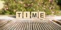 The word TIME written on the cubes in black letters