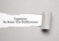 The word TOGETHER WE MAKE THE DIFFERENCE appearing behind torn brown paper Royalty Free Stock Photo