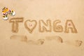 Word Tonga written in a sand