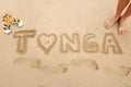 Word Tonga written in a sand