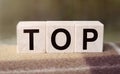 The word TOP is written on wooden cubes. Wooden cubes in the open air, overlooking the countryside. For business related design. Royalty Free Stock Photo