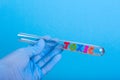 Word toxic in test-tube holding a gloved hand