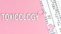 Word Toxicology on pink background, medical concept, top view