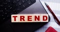 The word TREND is written on wooden cubes on the keyboard. Business concept Royalty Free Stock Photo