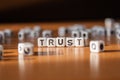 The word TRUST made of white plastic blocks on the table. Royalty Free Stock Photo