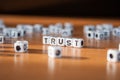 The word TRUST made of white plastic blocks on the table. Royalty Free Stock Photo
