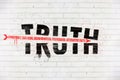 Truth destroyed with an arrow of conspiracy, fake news, disinformation, propaganda, alternative facts, painted on old white wall Royalty Free Stock Photo