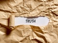 The word truth written under a brown torn paper
