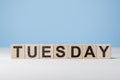 Word Tuesday on wooden cubes. Weekday concept. Tuesday inscription on wooden cubes on blue background. copy space