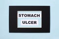 The word ulcer is written on paper in a black frame. Medical concept