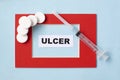 The word ulcer is written on paper in a red frame. Medical concept