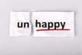 The word unhappy changed to happy on torn paper