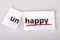 The word unhappy changed to happy on torn paper