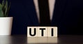 Word uti urinary tract infection on a wooden cubes on a blue background