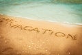 The word vacation written in the sand on a beach Royalty Free Stock Photo