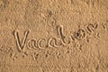 Word Vacation written in the sand on the beach.  Summer travel concept. Birds footprints on yellow sand Royalty Free Stock Photo