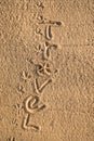 Word Vacation written in the sand on the beach.  Summer travel concept. Birds footprints on yellow sand Royalty Free Stock Photo