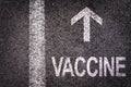 Word vaccine written on asphalt road with direction arrow covid-19 vaccination campaign concept