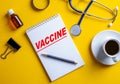 The word VACCINE is written in a white locot on a yellow background near the medical concept. Close-up from above