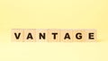 Word vantage with small wooden blocks on yellow background Royalty Free Stock Photo