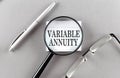 VARIABLE ANNUITY text written on a sticky with pencil and glasses