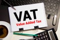Word VAT on sticker with pen glasses on documents. Tax time. Tax payment deadline