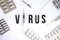 The word virus on a white background with syringe pills, medicines Royalty Free Stock Photo