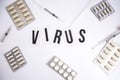 The word virus on a white background with syringe pills, medicines Royalty Free Stock Photo