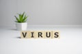 The word Virus on wooden cubes and syringe, blue background. Medical concept Royalty Free Stock Photo