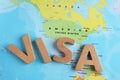 Word Visa made of wooden letters near USA on world map