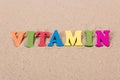 Word vitamin D of colored wooden letters on sandy beach