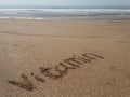 Word 'vitamin' written on the sand at a beach