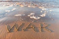 The word `war` on the sea sand, written with stick on the beach with foam