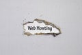 The word web hosting appearing behind torn paper Royalty Free Stock Photo