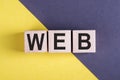 Word WEB on wooden cubes on yellow - gray background