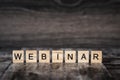 The word webinar is made of bright wood cubes with black letters