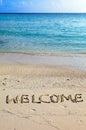 Word welcome is written on sand on oceanside Royalty Free Stock Photo