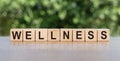 The word WELLNESS written on wooden cubes on wooden tables. Relax and care. Medical and health concept Royalty Free Stock Photo