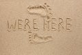 Word WERE HERE written on the sand