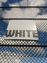 Word white on white sign board on mesh fence