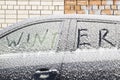 The word WINTER is painted on the glass of a car made of snow. The concept Royalty Free Stock Photo