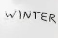 Word winter scraped by hand on the frozen rear glass of car, auto glass covered with snow, cold winter season concept, first Royalty Free Stock Photo