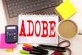 Word writing ADOBE in the office with laptop, marker, pen, stationery, coffee. Business concept for Software Company Name Worksho