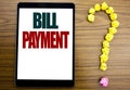 Word, writing Bill Payment. Business concept for Billing Pay Costs Written on tablet, wooden background with question mark on the Royalty Free Stock Photo