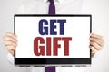 Word, writing Get Gift. Business concept for Free Shoping Coupon Written on tablet laptop holding by the man blurred background. B Royalty Free Stock Photo